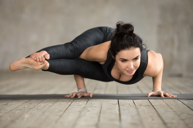 Giovane donna facendo esercizio Astavakrasana