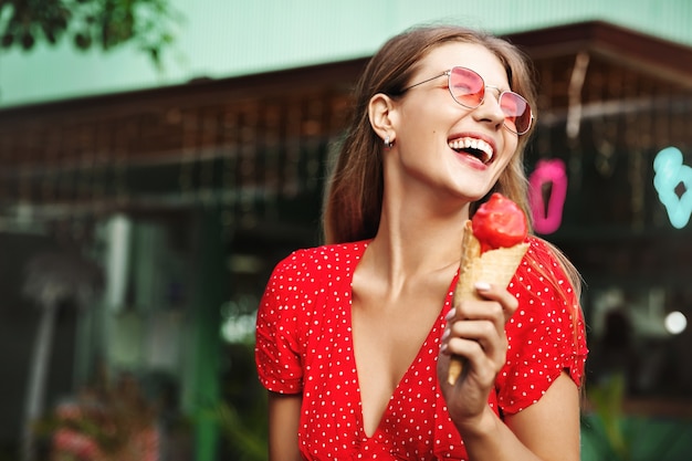 Giovane donna felice che mangia i dolci durante le vacanze estive