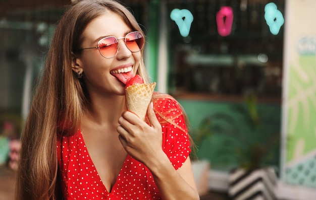 Giovane donna felice che mangia i dolci durante le vacanze estive