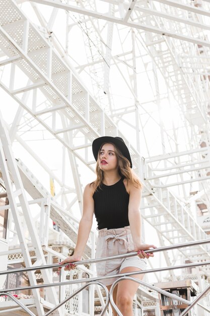 Giovane donna felice che posa con il cappello