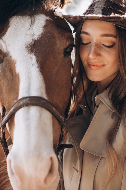 Giovane donna felice con cavallo al ranch