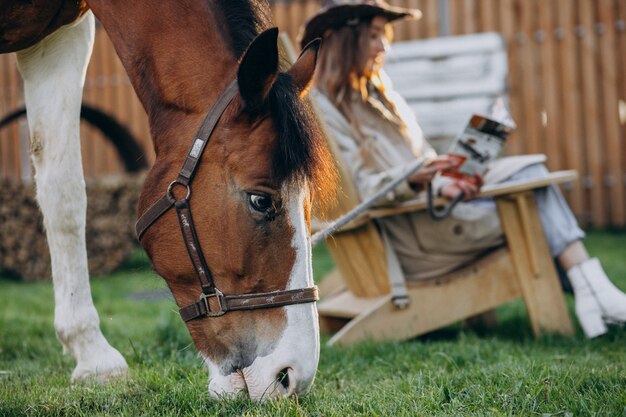 Giovane donna felice con cavallo al ranch