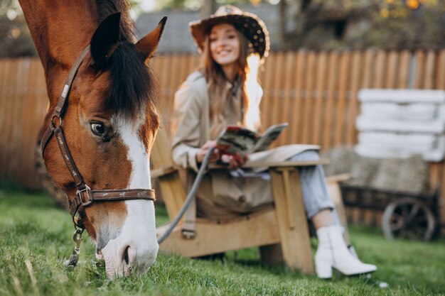 Giovane donna felice con cavallo al ranch