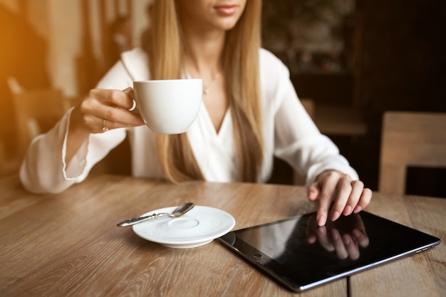 Giovane donna felice di caffè da tavoletta