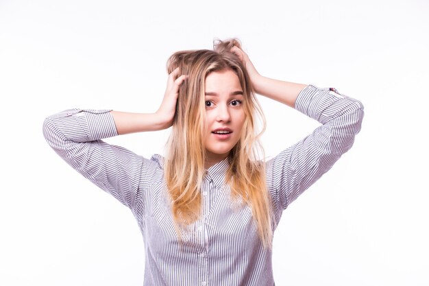 Giovane donna felice sorpresa che osserva obliquamente per l'eccitazione. Isolato sopra il muro bianco