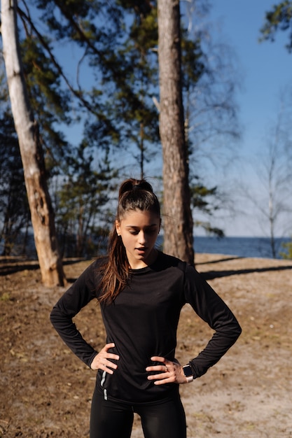 Giovane donna fitness cammina nel parco e in posa