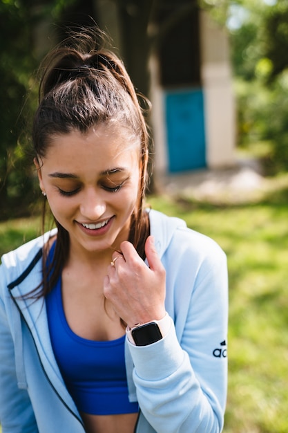 Giovane donna fitness cammina nel parco e in posa