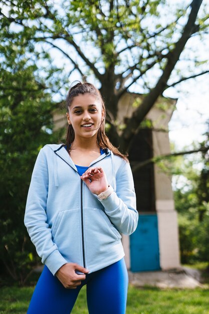 Giovane donna fitness cammina nel parco e in posa