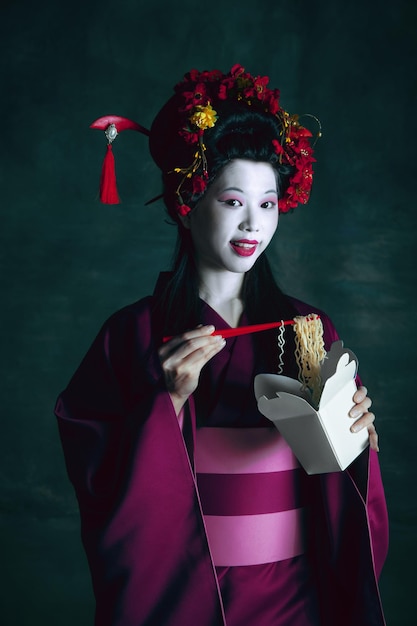 Giovane donna giapponese come geisha. Stile retrò, concetto di confronto di epoche.