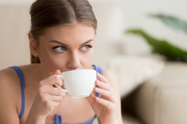 Giovane donna godendo caldo caffè preparato fresco