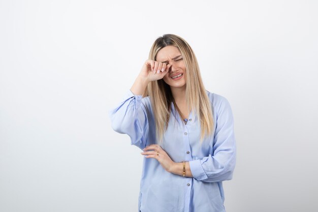 giovane donna graziosa che piange su sfondo bianco.