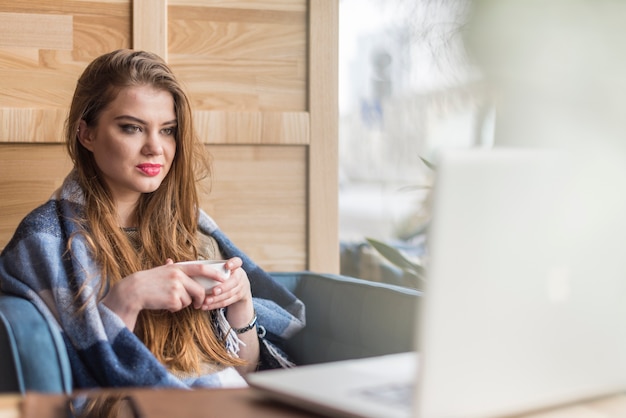 Giovane donna guardando il suo schermo del computer portatile