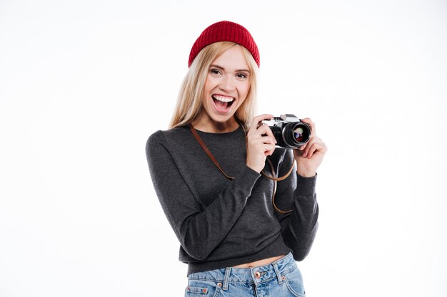 Giovane donna in abbigliamento casual che sta e che tiene retro macchina fotografica