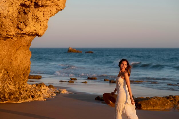 Giovane donna in abito bianco vicino al mare