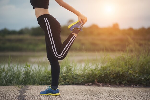 Giovane donna in buona salute che si scalda allenamento all&#39;aperto prima dell&#39;allenamento al parco.