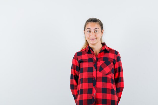 Giovane donna in camicia casual che guarda l'obbiettivo e sembra incantevole, vista frontale.