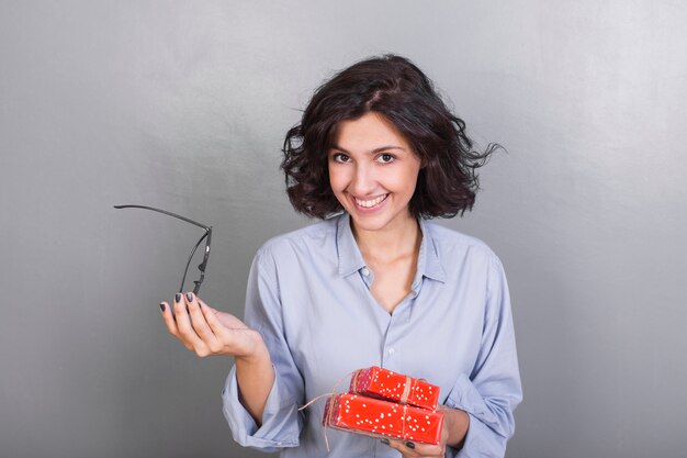 Giovane donna in camicia con scatole regalo