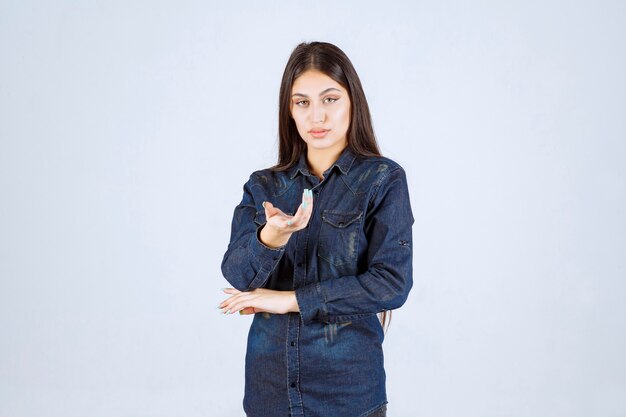 Giovane donna in camicia di jeans che punta alla persona di fronte a lei