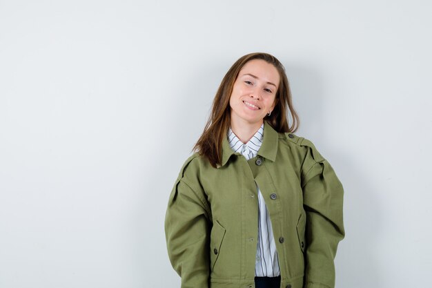 Giovane donna in camicia, giacca che guarda l'obbiettivo e sembra attraente, vista frontale.