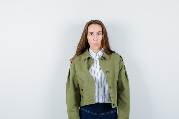 Giovane donna in camicia, giacca che guarda l'obbiettivo e sembra perplessa, vista frontale.