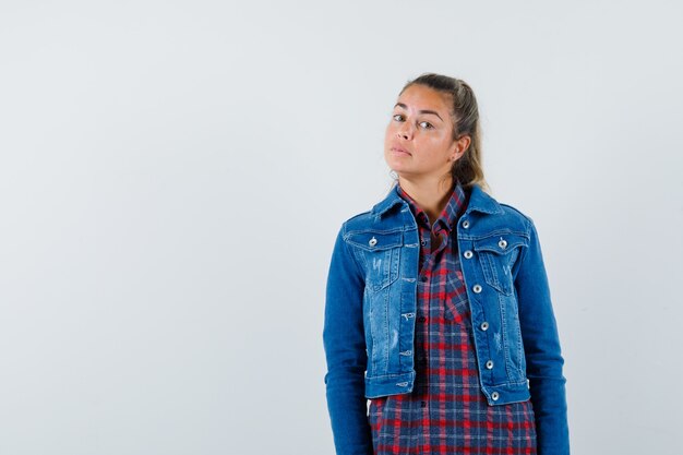 Giovane donna in camicia, giacca che guarda l'obbiettivo e sembra ragionevole, vista frontale.