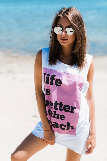 Giovane donna in canottiera oversize sulla spiaggia