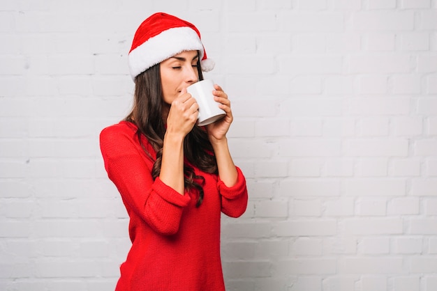 Giovane donna in cappello del partito con la tazza