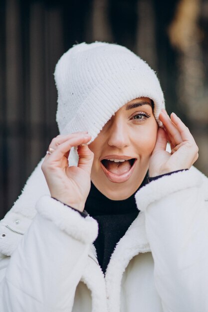 Giovane donna in cappello invernale in piedi all'aperto