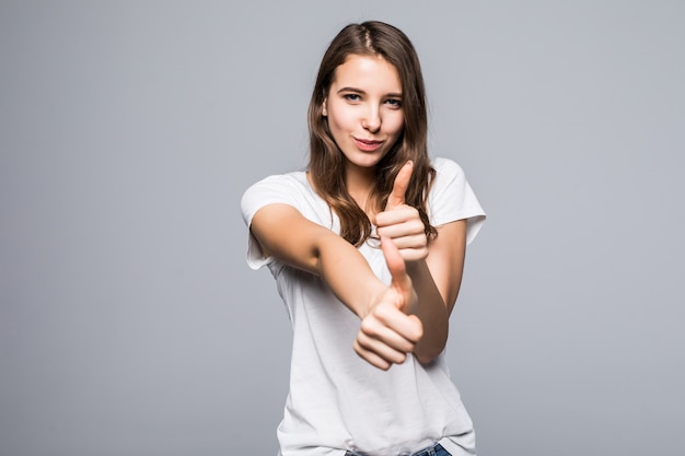 Giovane donna in maglietta bianca e blue jeans davanti a sfondo bianco studio