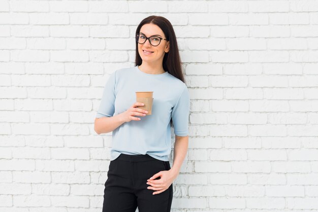 Giovane donna in piedi con una tazza di caffè