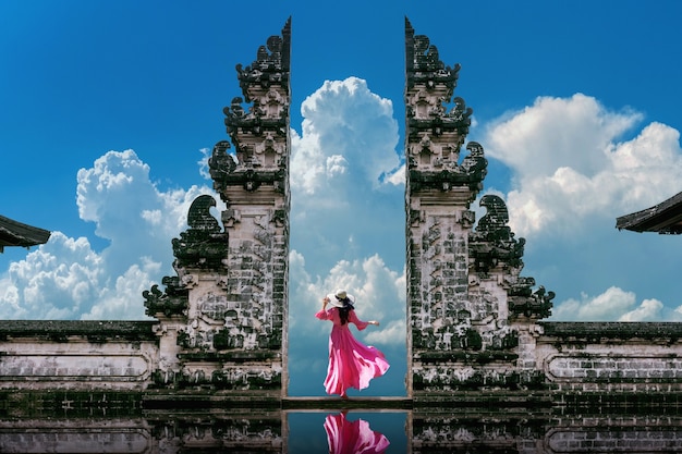 Giovane donna in piedi nei cancelli del tempio al tempio di Lempuyang Luhur a Bali, Indonesia. Tono vintage