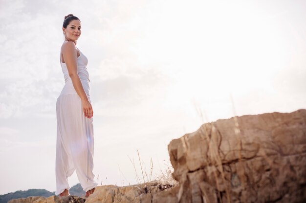 Giovane donna in piedi sulla roccia