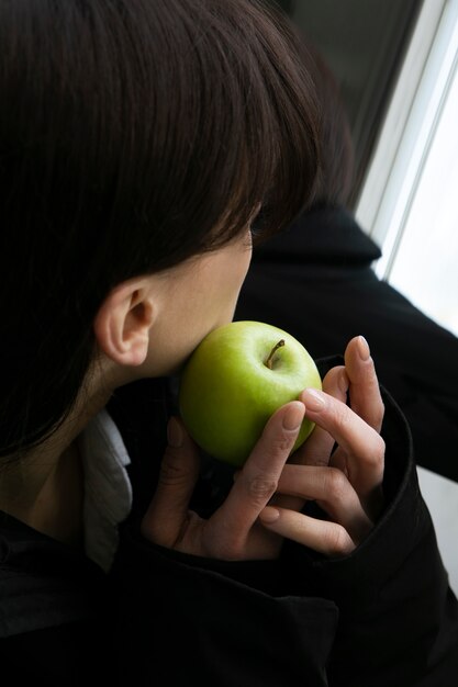 Giovane donna in posa accanto allo specchio con la mela