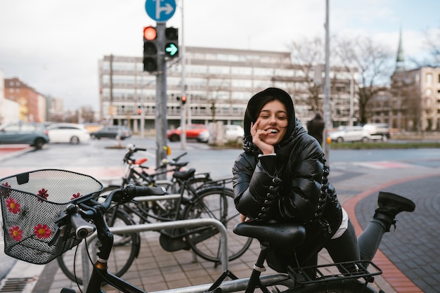 Giovane donna in posa in un parcheggio con le biciclette