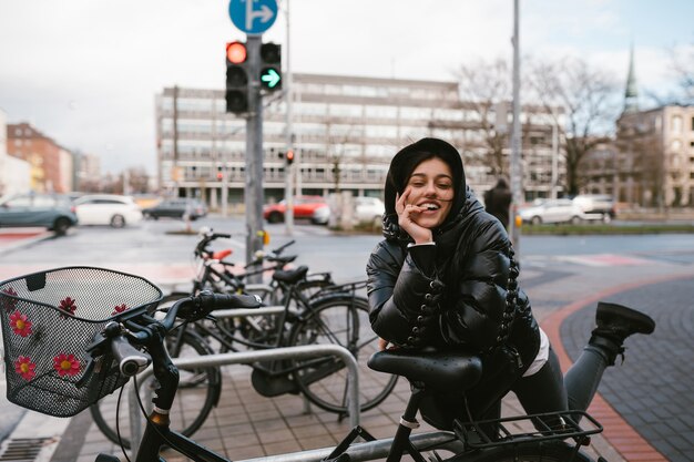 Giovane donna in posa in un parcheggio con le biciclette