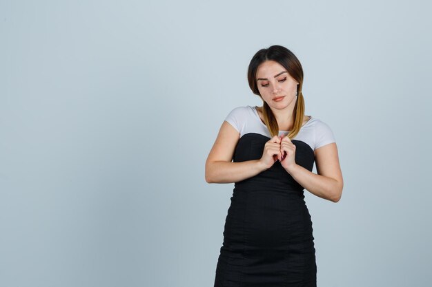 Giovane donna in posa mentre tiene una ciocca di capelli