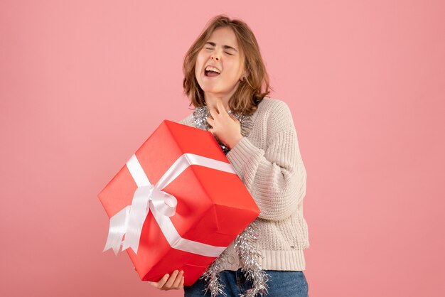 giovane donna in possesso di Natale presente sul rosa