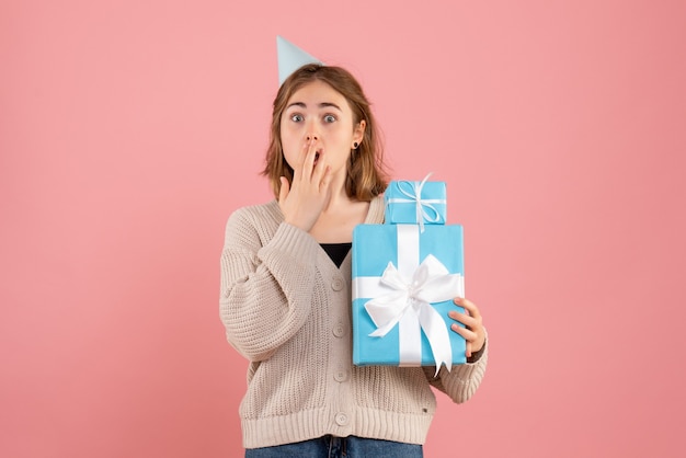 giovane donna in possesso di regali di Natale in rosa