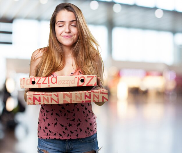 giovane donna in possesso di un scatole per pizza su sfondo bianco