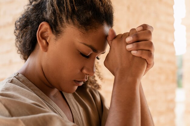 Giovane donna in preghiera con un colpo medio