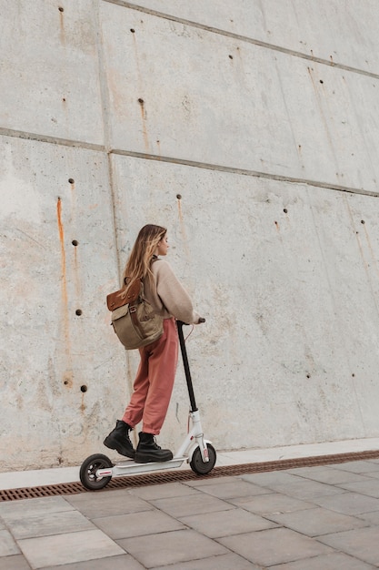 Giovane donna in sella a uno scooter elettrico