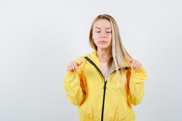 Giovane donna in t-shirt, giacca con la punta rivolta verso il basso e guardando fiducioso