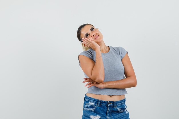 Giovane donna in t-shirt, pantaloncini alzando lo sguardo e guardando premuroso