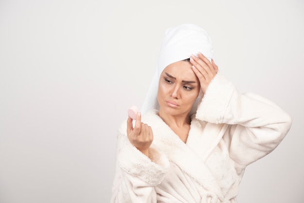 Giovane donna in un accappatoio che fa il trucco.