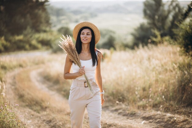 Giovane donna in un cappello in un campo di grano