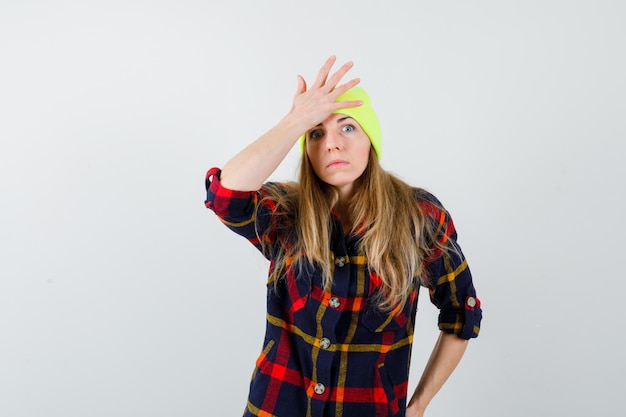 Giovane donna in una camicia a scacchi con un cappello