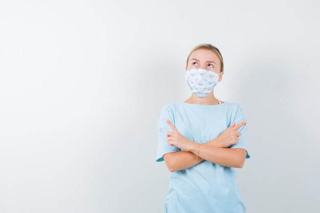 Giovane donna in una maglietta blu con una maschera medica
