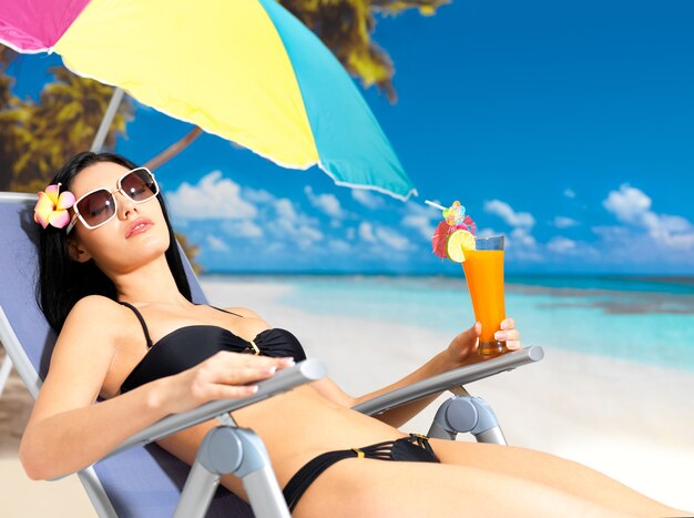 Giovane donna in vacanza godendo in spiaggia sotto il sole