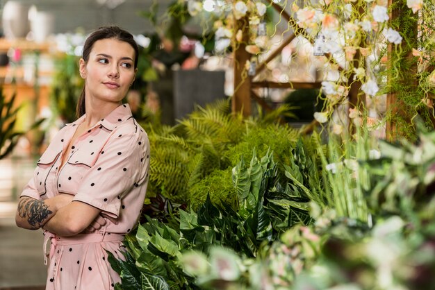 Giovane donna in vestito che sta nella serra