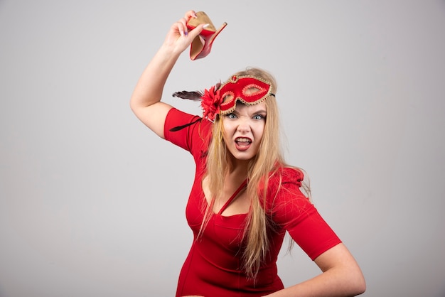 Giovane donna in vestito rosso che lancia il suo tallone.